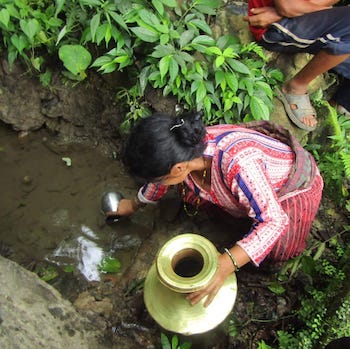 Women in Nepal get water from stream